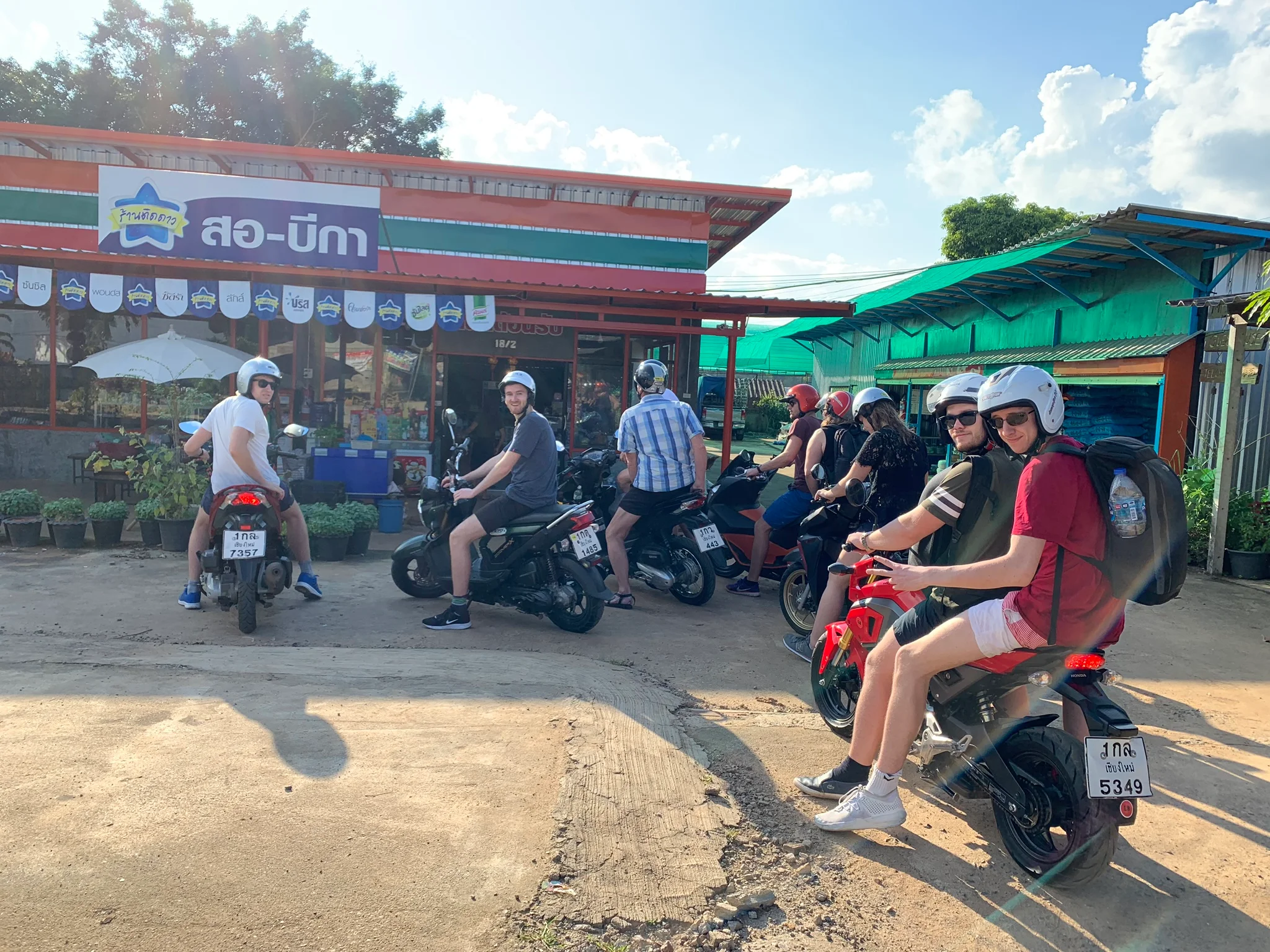Den danske delegation på scooter-tur gør pause foran en butik i bjergene